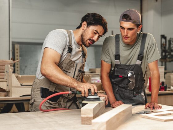 Auzubildender schaut Handwerker zu